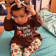 Zhurysadaii joined the competition — help win amazing prizes! toddler, child, indoor, bed, clothing, headband, brown_shirt, thanksgiving, pants, socks, face, hair, hand, furniture, laundry_basket, blanket, expression, person, cute, home