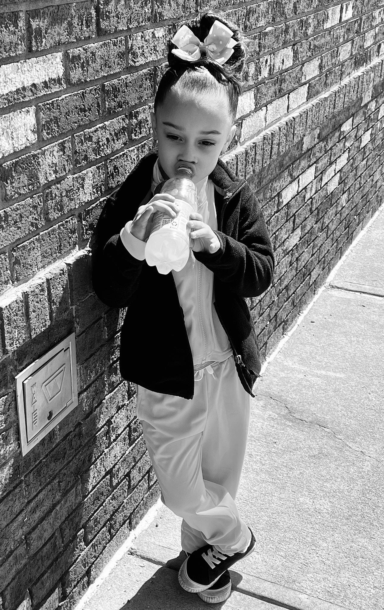 Charli is registered to the contest to win money with this photo: black, black_and_white, child, cool, eyewear, face, gesture, happy, head, monochrome, monochrome_photography, person, photograph, shoe, snapshot, sneakers, standing, style, sunglasses, toddler