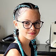 Liwen participe au concours pour gagner de l'argent avec cette photo : child, girl, braids, blue_hair, glasses, smile, portrait, indoor, kitchen, black_top, young, person, hairstyle, face, necklace, fashion, casual, happy, cute, modern