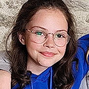 Liwen participe au concours pour gagner de l'argent avec cette photo : blue_hoodie, casual_clothing, child, eyewear, face, freckles, friendly, girl, glasses, happy, head_and_shoulders, human, indoors, light_skin, long_hair, natural_light, person, portrait, smile, young