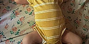Jaeger joined the competition — help win amazing prizes! baby, infant, yellow_onesie, floral_bed_sheet, lying_down, arms_up, curious_expression, indoors, cute, child, person, skin, legs, feet, head, hair, mouth, face, sleepwear, bedroom