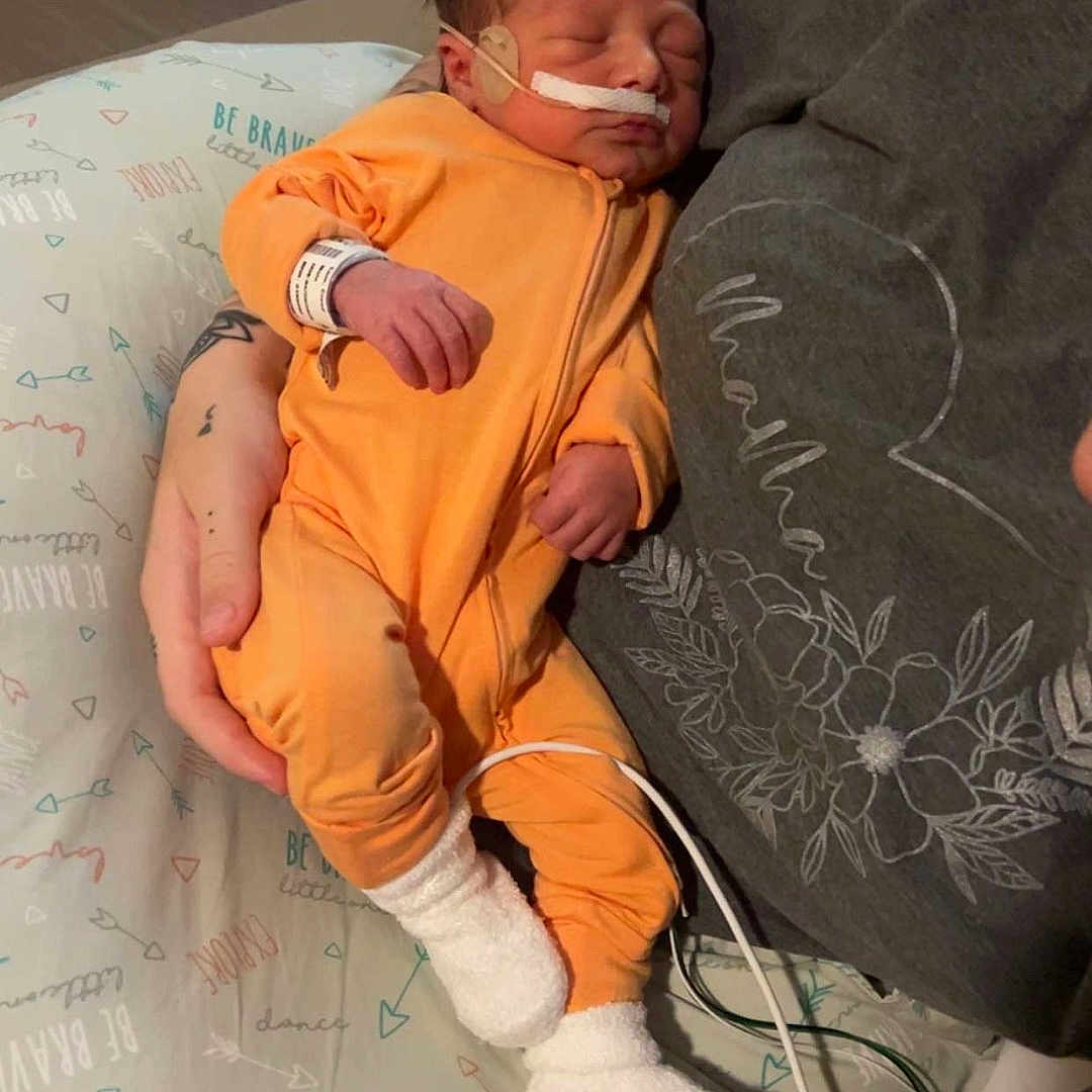 Creed is registered to the contest to win money with this photo: architecture, baby, building, clothing, cushion, face, furniture, head, homedecor, hosiery, hospital, machine, newborn, person, photography, portrait, skin, sock, tattoo, wheel