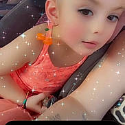 Sarah is registered to the contest to win money with this photo: child, toddler, face, portrait, car_seat, seated, indoors, sparkles, filter, orange_clothing, pink_clothing, looking_at_camera, short_hair, earring, bracelet, vehicle, close_up, digital_effects, family, photograph