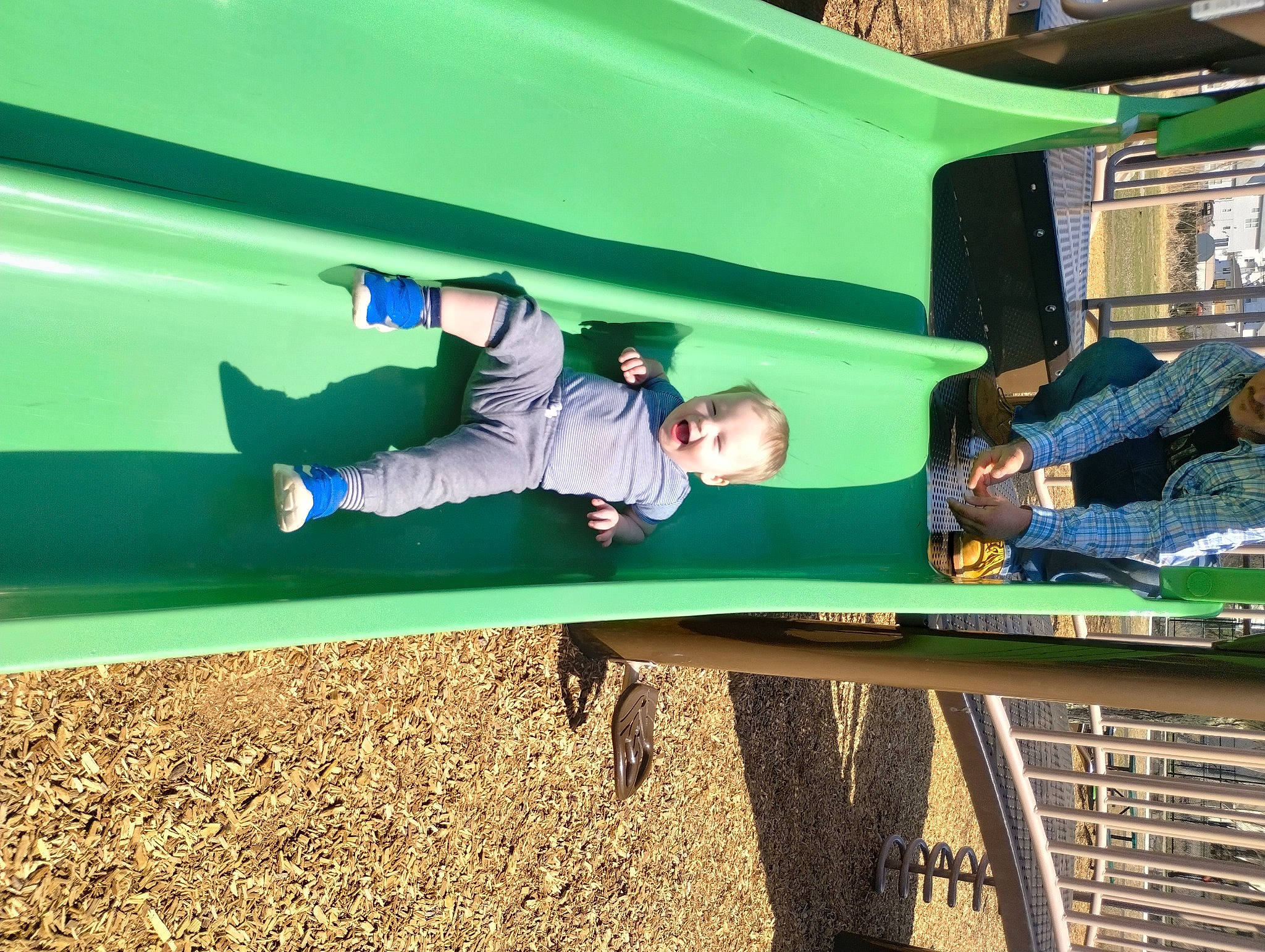 Kaleb is registered to the contest to win money with this photo: automotive_exterior, child, chute, city, electric_blue, fun, grass, leisure, motor_vehicle, outdoor_play_equipment, person, play, playground, playground_slide, recreation, shade, sleeve, soil, t_shirt, toddler