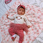 Jaylah Alani is registered to the contest to win money with this photo: baby, infant, blanket, headband, tutu, leggings, pink, white, floral, flower_pattern, cute, lying_down, child, face, clothing, sock, soft_texture, indoors, portrait, young_child