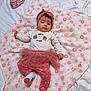 baby, infant, blanket, headband, tutu, leggings, pink, white, floral, flower_pattern, cute, lying_down, child, face, clothing, sock, soft_texture, indoors, portrait, young_child