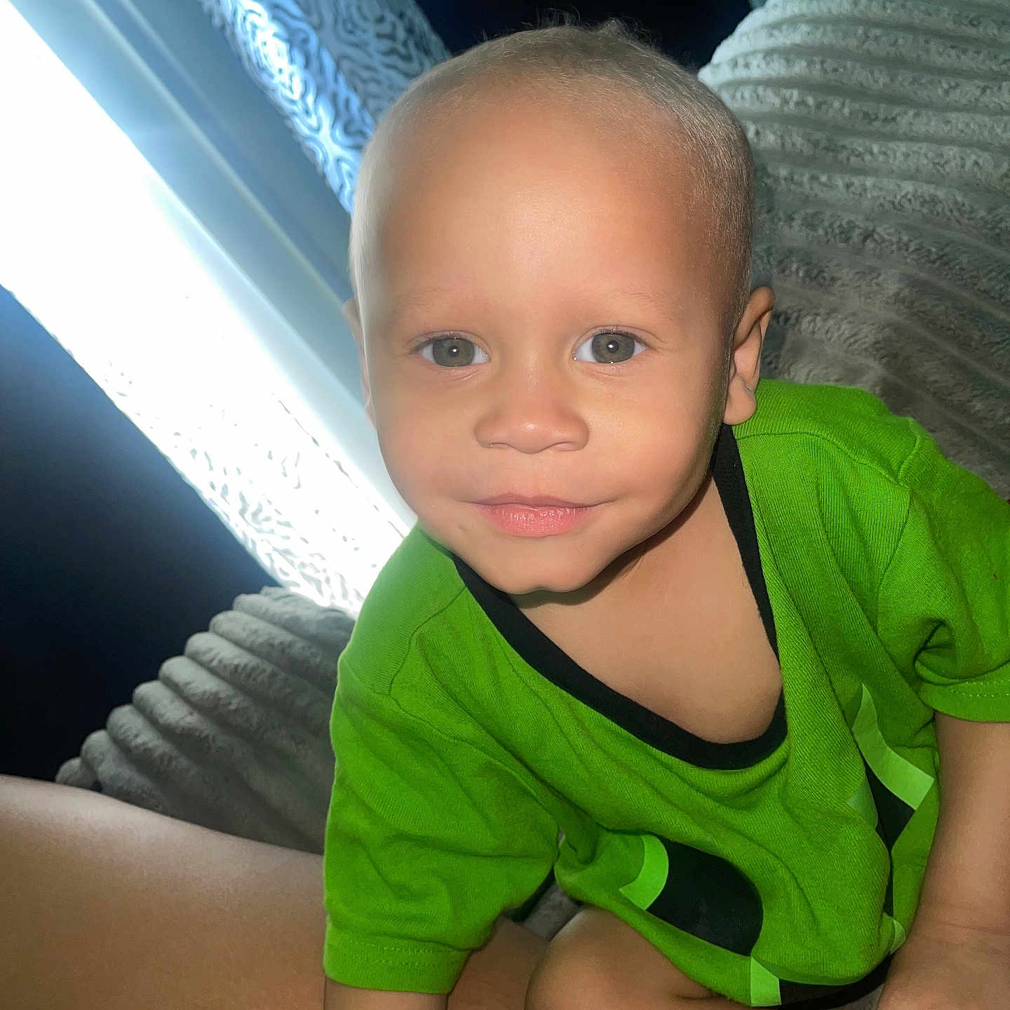 Kaysion is registered to the contest to win money with this photo: toddler, child, baby, portrait, face, smiling, eyes, green_shirt, clothing, sitting, couch, sofa, indoor, window, curtain, daylight, closeup, home, person, photography