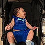 baby, child, blue_clothing, puma_logo, stroller, socks, indoor, playful, tongue_out, person, seated, black_stroller, happy, infant, cute, footwear, young_child, smiling, baby_clothes, mesh_back