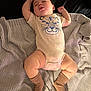 baby, sleeping, onesie, socks, blanket, infant, cute, cozy, child, soft_texture, indoor, resting, peaceful, relaxed, person, comfort, skin, face, legs, arm