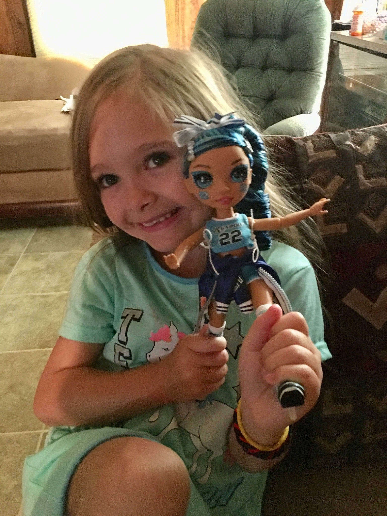 Kaitlyn is registered to the contest to win money with this photo: camera, cameras_optics, child, comfort, eyewear, fiddle, flooring, fun, glass, hand, happy, joy, leisure, living_room, person, selfie, sitting, smile, stuffed_toy, toddler