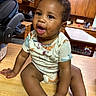 Cj is registered to the contest to win money with this photo: baby, infant, child, kitchen, counter, wooden_surface, messy_face, curly_hair, short_sleeve_shirt, sitting, indoors, happy, cute, person, cabinet, appliance, table, home, curious, smiling