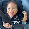 baby, car_seat, seatbelt, smiling, happy, child, infant, black_clothing, hand, face, curly_hair, car_interior, sitting, young_child, portrait, cute, joyful, safety, seat, cute_expression