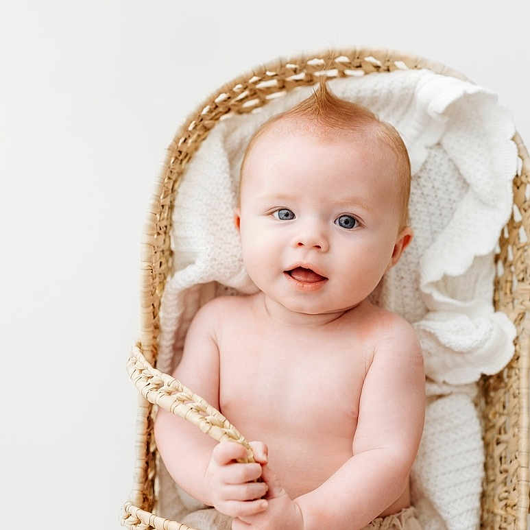 Landon is registered to the contest to win money with this photo: baby, basket, bed, blanket, bonnet, clothing, crib, face, furniture, happy, hat, head, infantbed, newborn, person, photography, portrait, sitting, smile, towel