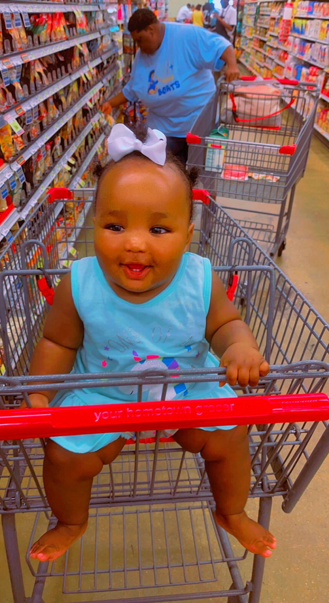 Londynn is registered to the contest to win money with this photo: baby_toddler_clothing, blue, cart, child, fun, happy, human_leg, leg, leisure, magenta, person, red, shelf, shopping, shopping_cart, shorts, skin, smile, snapshot, toddler