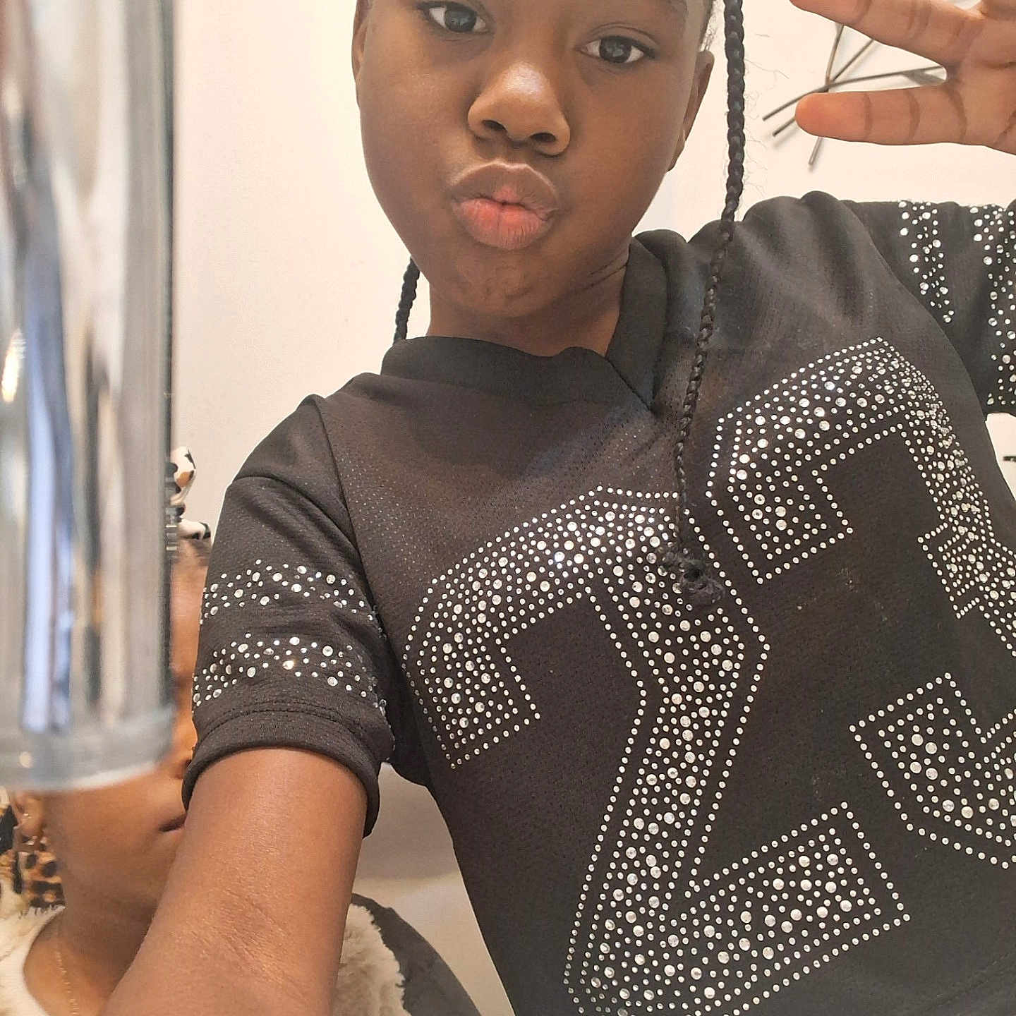 Darra is registered to the contest to win money with this photo: child, girl, selfie, peace_sign, black_shirt, studs, braids, indoor, person, portrait, casual, smile, hand_gesture, young, face, arm, mirror, reflection, metallic_object, background