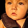 baby, child, closeup, cute, dark_background, expression, eyelashes, eyes, face, harness, head, human, infant, portrait, serious, skin, straps, sunlight, warm_light, young