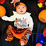 baby, infant, halloween, pumpkin, orange, black, headband, tutu, leaves, hand, blanket, lights, holiday, festive, cute, clothing, foot, smiling, person, celebration
