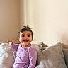 Amanda joined the competition — help win amazing prizes! baby, child, smiling, happy, couch, pillows, indoors, onesie, purple_clothing, hair, portrait, sitting, cute, infant, person, toddler, face, expression, home, cozy