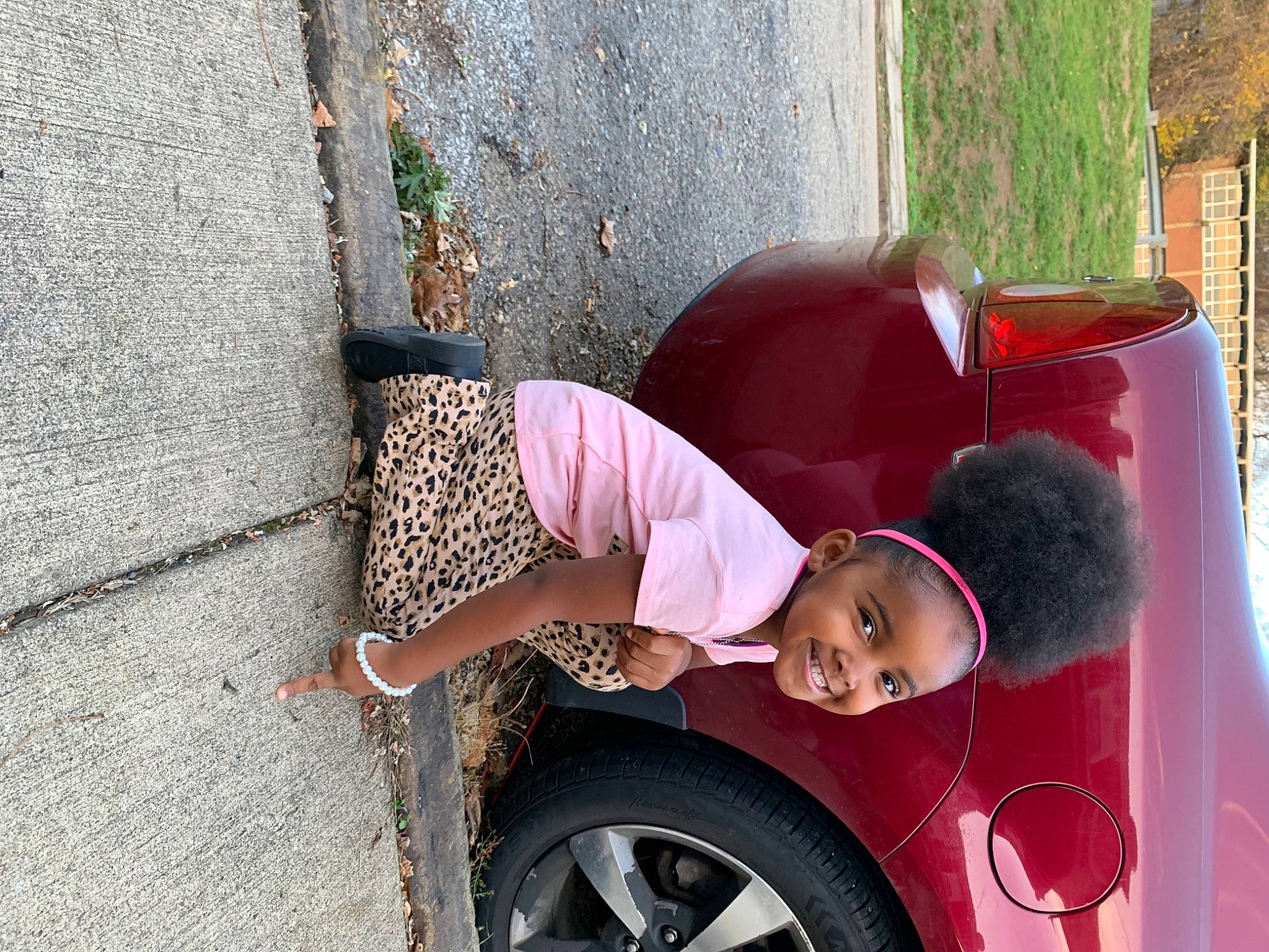 Ma Leah is registered to the contest to win money with this photo: automotive_design, automotive_exterior, automotive_lighting, automotive_tire, car, dress, fender, hat, joy, land_vehicle, motor_vehicle, person, photograph, plant, red, street_fashion, tire, tread, vehicle, vehicle_door