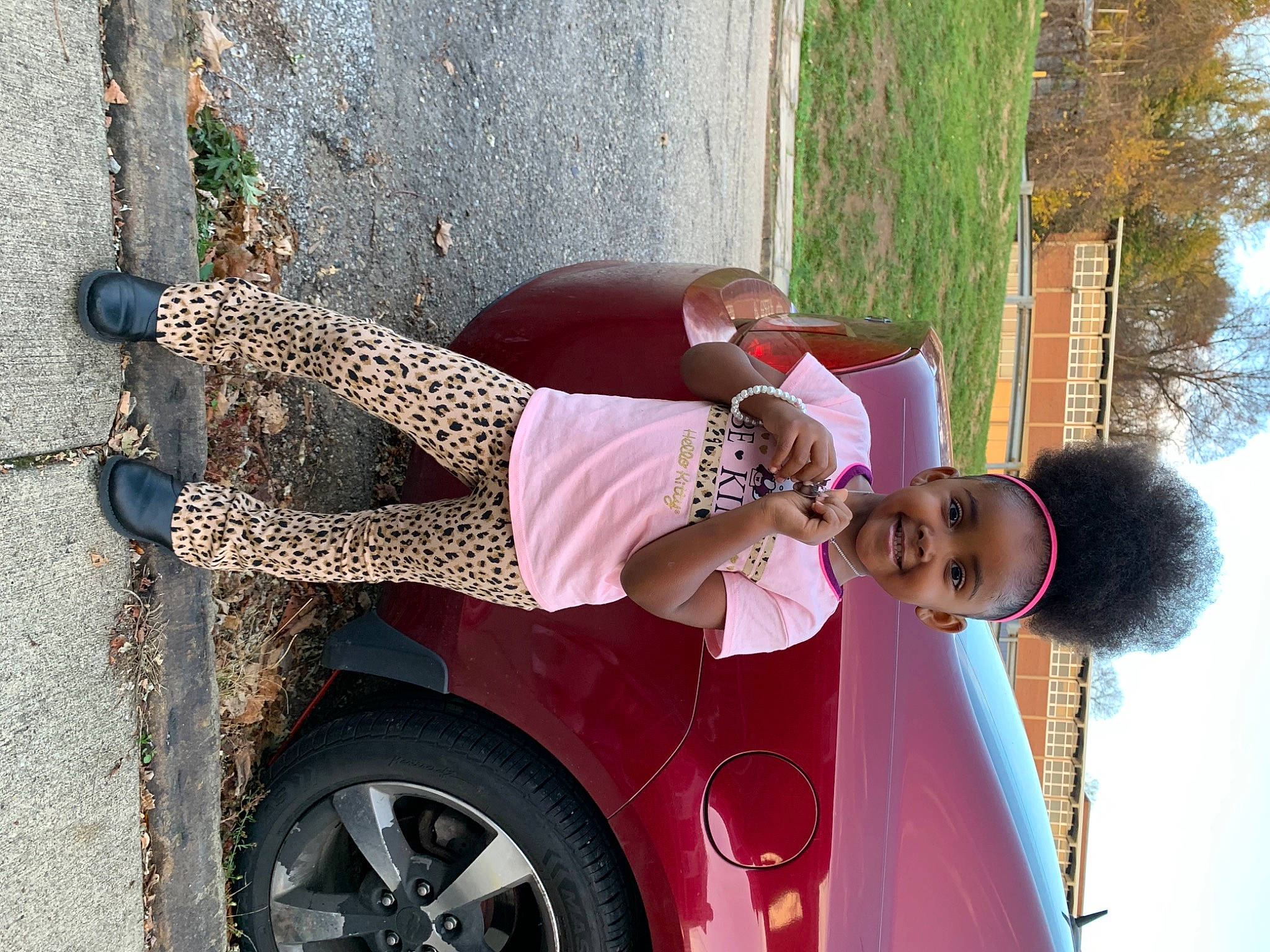 Ma Leah is registered to the contest to win money with this photo: arm, automotive_design, automotive_exterior, automotive_tire, car, fender, hubcap, joy, motor_vehicle, person, red, rim, street_fashion, sunglasses, thigh, tints_and_shades, tire, tree, vehicle, vehicle_door