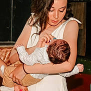 Caraiman Mihaela a rejoint le concours — aidez-le/la à gagner de superbes lots ! woman, baby, feeding, bottle, holding, white_dress, indoor, child, person, infant, care, love, tenderness, family, portrait, human, hair, skin, nurturing, clothing