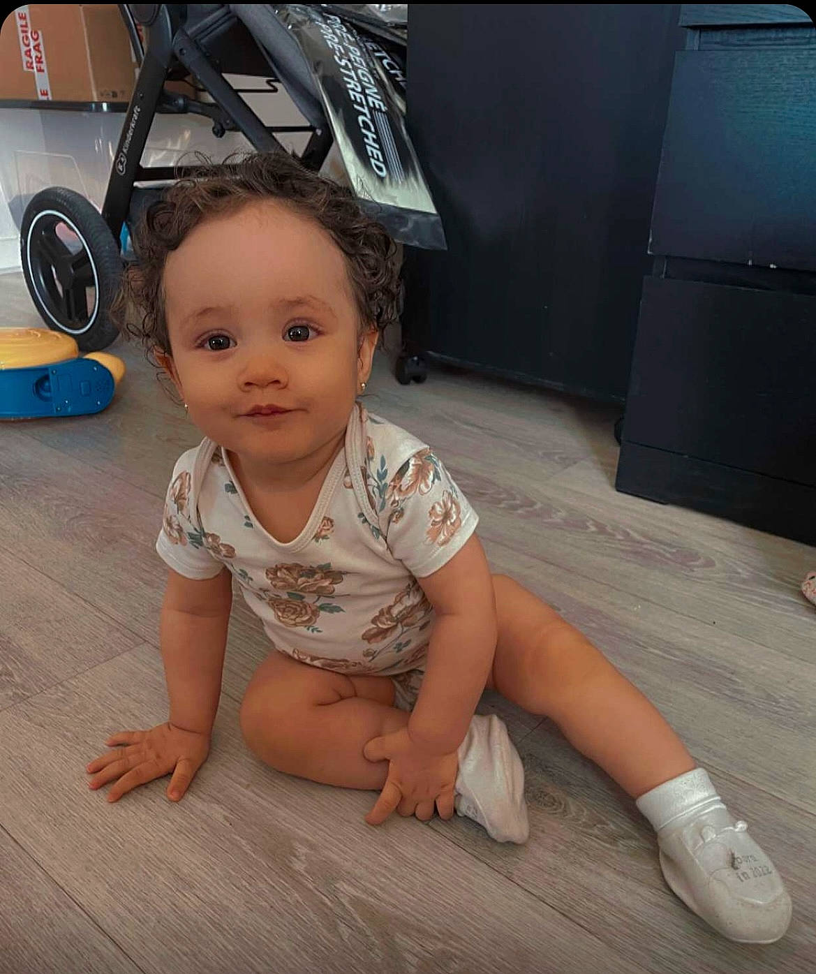 Arya a rejoint le concours — aidez-le/la à gagner de superbes lots ! baby, baby_toddler_clothing, barefoot, comfort, crawling, floor, flooring, foot, fun, happy, hardwood, human_leg, joint, joy, leg, person, sitting, thigh, tire, toddler