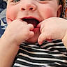 Asher joined the competition — help win amazing prizes! baby, child, face, hands, striped_shirt, chewing, cute, infant, playful, lying_down, blanket, patterned_blanket, floral_pattern, skin, cheeks, mouth, eyes, person, portrait, indoor