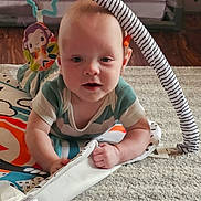 Asher is registered to the contest to win money with this photo: baby, child, play_mat, toy, floor, carpet, infant, tummy_time, colorful, curious, indoors, cute, person, childhood, crawling, soft, playtime, clothing, smiling, young