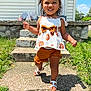 toddler, child, smiling, outdoor, sunny, grass, steps, house, sidewalk, sandals, hair_bows, shorts, top, shadow, concrete, happy, walking, summer, portrait, person