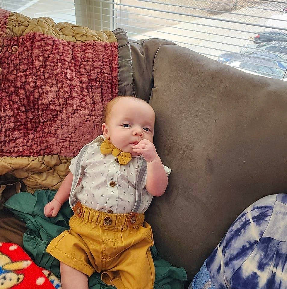 Emilio joined the competition — help win amazing prizes! baby, baby_toddler_clothing, child, comfort, couch, flooring, fun, happy, lap, linens, living_room, mammal, pattern, person, pillow, room, sitting, textile, throw_pillow, toddler