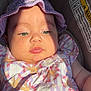 baby, infant, child, car_seat, purple_hat, floral_dress, sunlight, face, portrait, closeup, cute, soft_skin, warning_label, seatbelt, summer_clothing, outdoor_light, expressionless, headwear, seat, child_safety