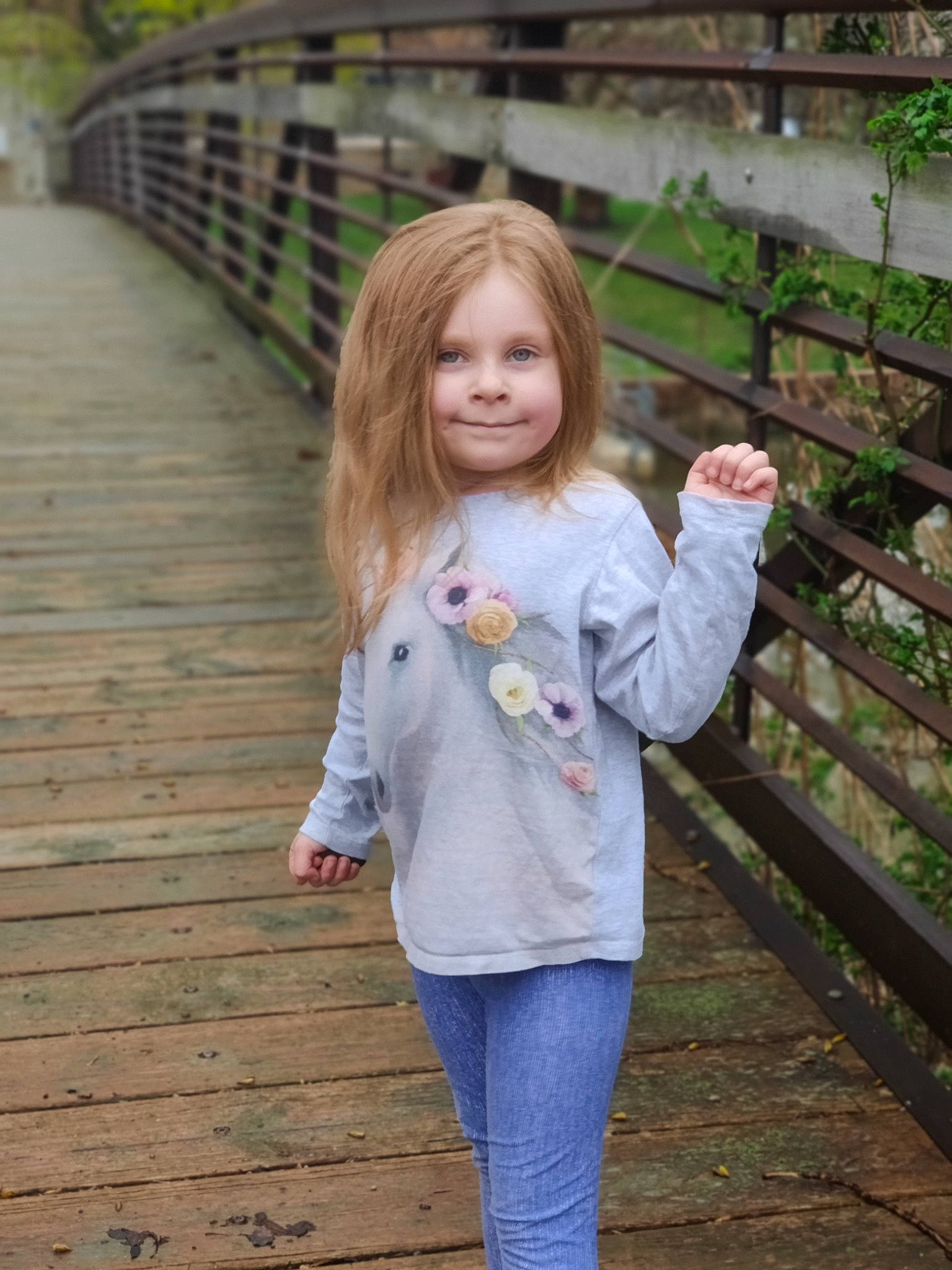 Lillith is registered to the contest to win money with this photo: bangs, blond, brown_hair, child, denim, fence, grass, happy, jeans, joy, leaf, leisure, long_hair, people_in_nature, person, plant, skin, standing, summer, t_shirt