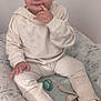 Nathan participe au concours pour gagner de l'argent avec cette photo : baby, changing_pad, child, clothing, cute, dinosaur, expression, face, footwear, hand, hoodie, indoor, pacifier, pants, person, sitting, socks, soft_lighting, toddler, young