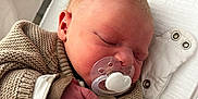 Sacha participe au concours pour gagner de l'argent avec cette photo : newborn, baby, sleeping, pacifier, knitted_sweater, blanket, hospital_bassinet, infant, cozy, resting, cute, child, bed, clothing, hand, face, skin, indoors, soft, peaceful