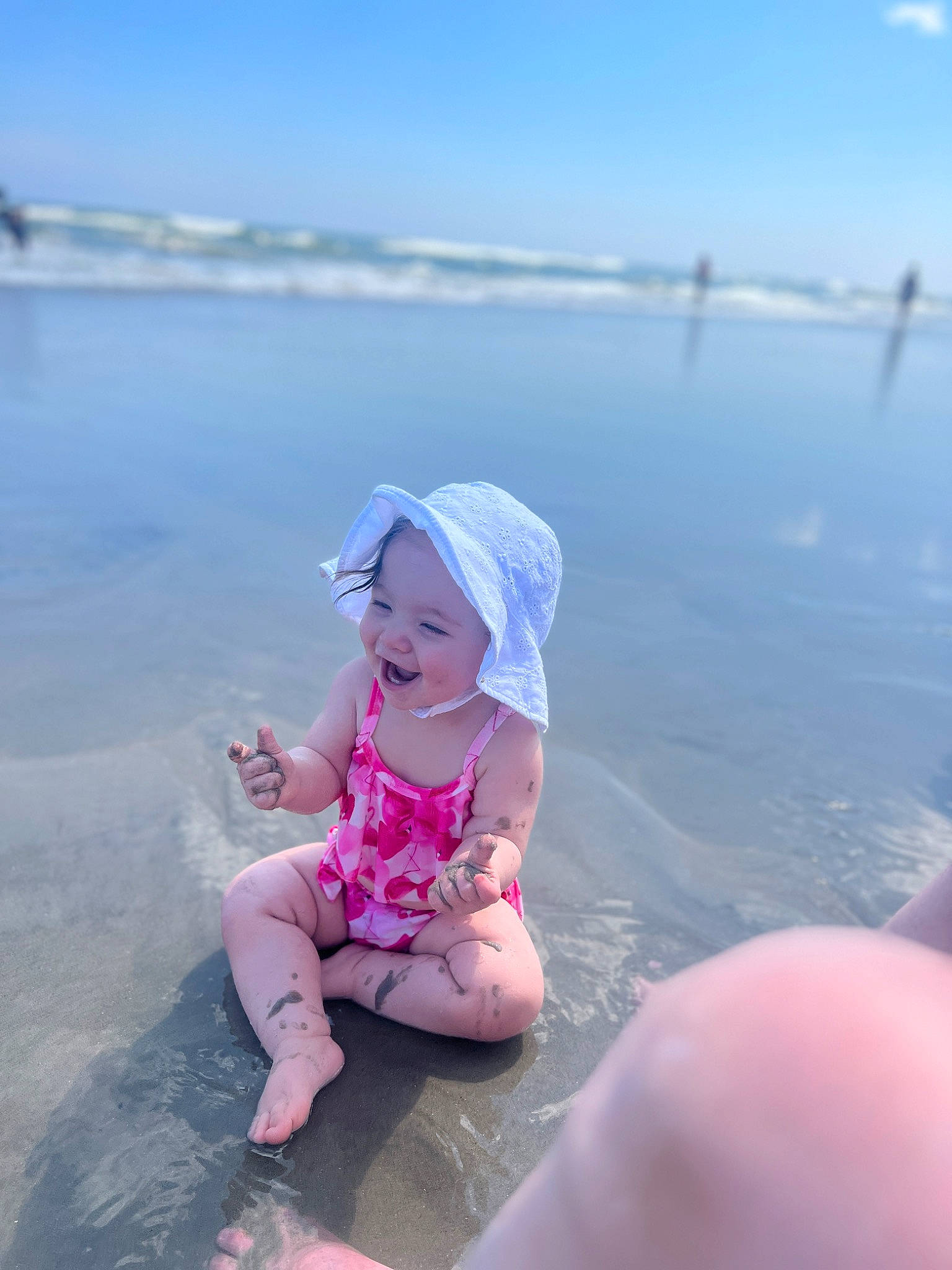 Vienna is registered to the contest to win money with this photo: baby, beach, body_of_water, cap, cloud, flash_photography, fun, happy, hat, headwear, horizon, lake, landscape, leisure, person, recreation, sand, sky, toddler, travel
