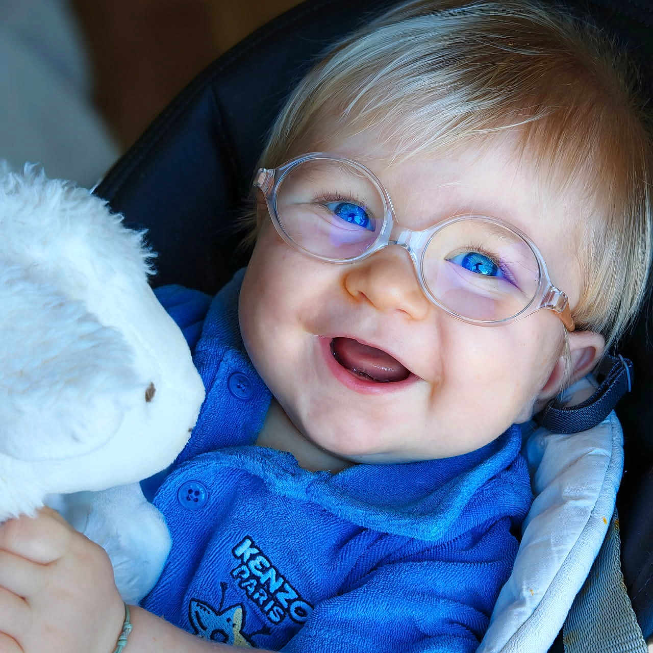 Don Carlu a rejoint le concours — aidez-le/la à gagner de superbes lots ! accessory, baby, blue_eyes, blue_shirt, child, closeup, clothing, cushion, cute, glasses, happy, indoor, infant, person, plush_toy, portrait, seated, smiling, soft_toy, teddy_bear