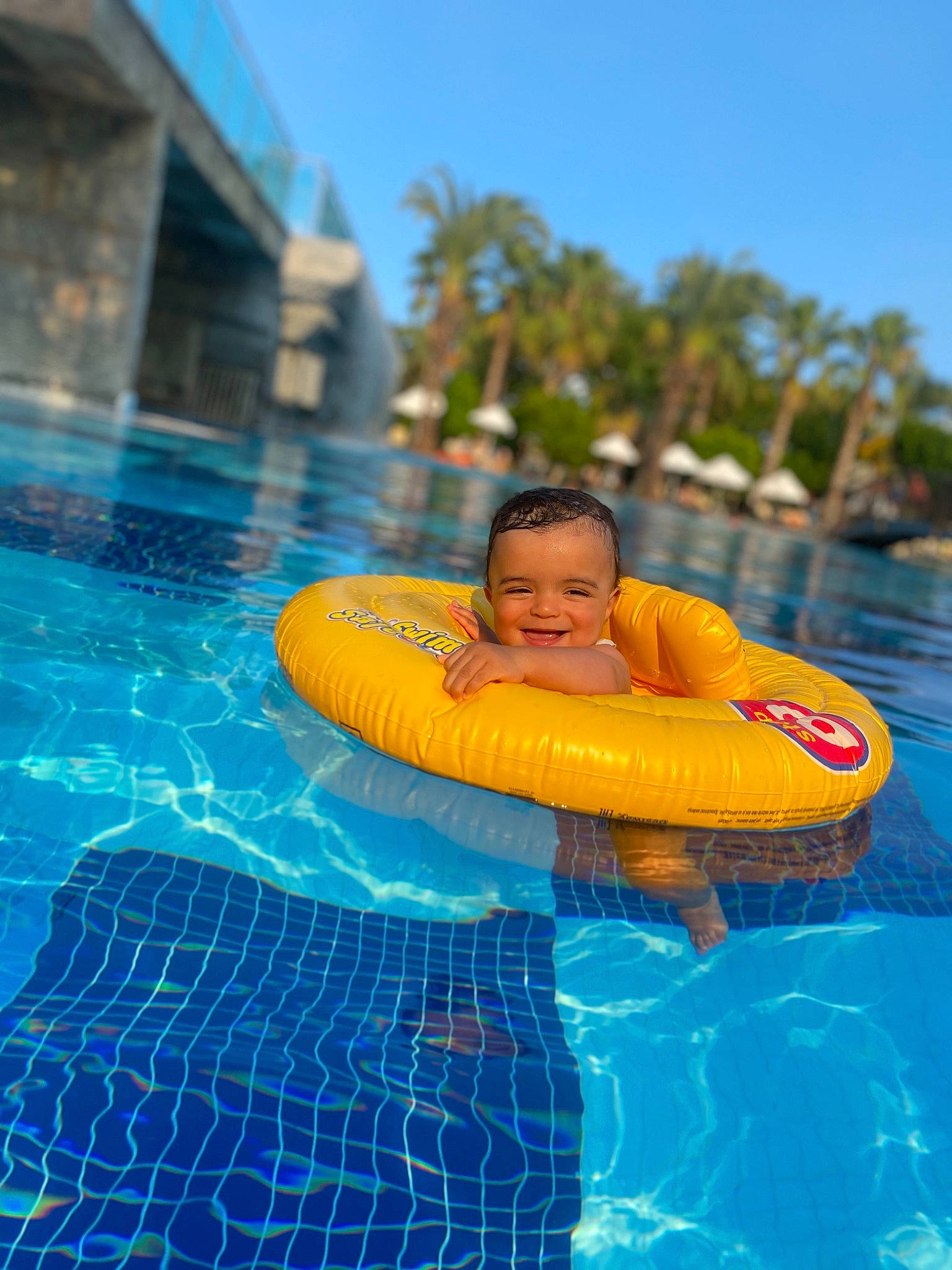 Aliyah participe au concours pour gagner de l'argent avec cette photo : aqua, azure, baby_float, electric_blue, fun, games, happy, inflatable, joy, leisure, nonbuilding_structure, person, personal_protective_equipment, play, recreation, sky, swimming_pool, toddler, tree, tubing