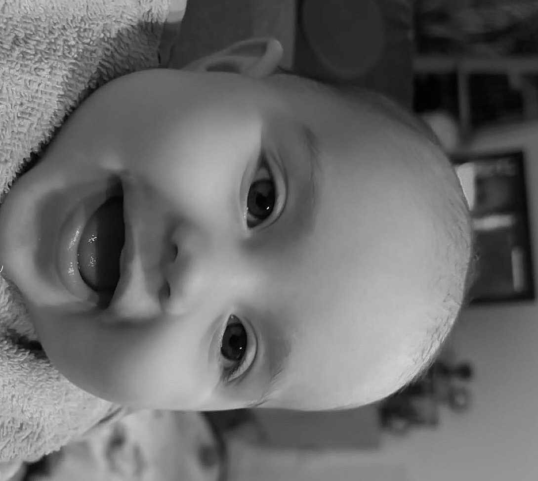 Maé a rejoint le concours — aidez-le/la à gagner de superbes lots ! baby, infant, face, close_up, black_and_white, towel, happy, smiling, mouth_open, eyes, skin, head, child, indoor, portrait, cute, person, expression, young, babyface