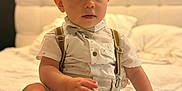 Charles participe au concours pour gagner de l'argent avec cette photo : baby, bed, blue_eyes, bowtie, child, clothing, curious, cute, headboard, indoor, person, portrait, shirt, shoes, shorts, sitting, suspenders, toddler, white_bedspread, young