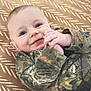 Tripp joined the competition — help win amazing prizes! baby, child, smiling, face, blue_eyes, camouflage_clothing, hands, lying_down, blanket, pattern, indoor, cute, infant, portrait, happy, young_child, clothing, toddler, skin, person