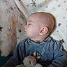baby, sleeping, plush_toy, blanket, star_pattern, soft_lighting, indoor, peaceful, child, infant, cute, portrait, cozy, clothing, head, face, person, rest, comfort, toddler