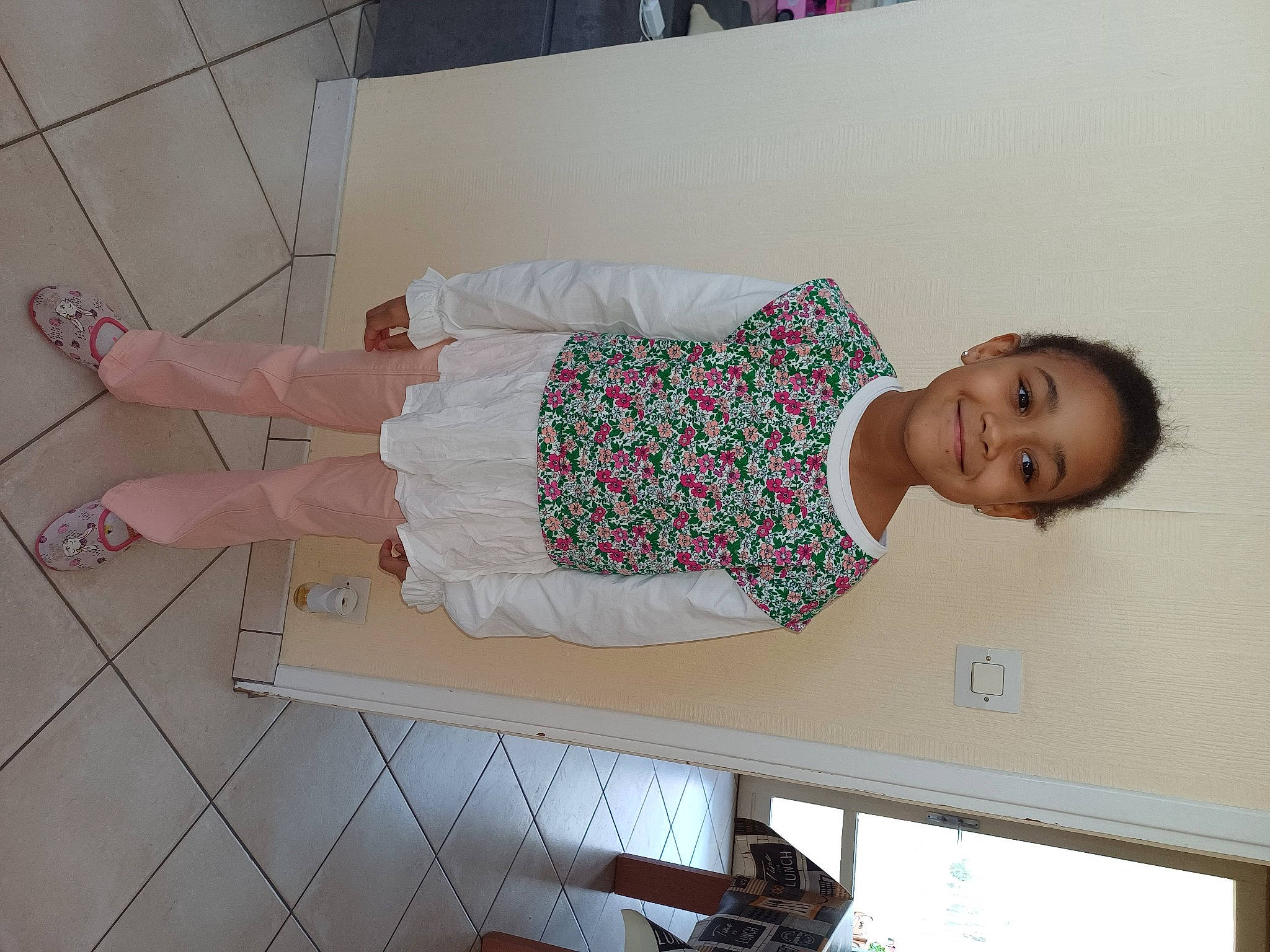 Léa a rejoint le concours — aidez-le/la à gagner de superbes lots ! baby_toddler_clothing, child, comfort, day_dress, flooring, foot, fun, happy, hardwood, human_leg, joy, knee, pattern, person, room, sandal, smile, thigh, toddler, wood