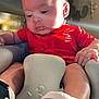 baby, infant, child, red_shirt, converse_shoes, sneakers, seat, cushion, indoor, sunlight, hand, footwear, portrait, young_child, casual_clothing, soft_light, curious, cute, comfortable, baby_seat