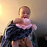 Suliana is registered to the contest to win money with this photo: baby, child, infant, smile, mittens, pink_clothing, person, adult_hands, holding, indoor, warm_lighting, happy, cute, portrait, head, face, skin, clothing, joy, family