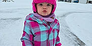 Lilya is registered to the contest to win money with this photo: child, cold_weather, curious, daytime, face, footwear, gloves, houses, jacket, neighborhood, outdoor, pants, person, pink_hat, playing_outside, scarf, snow, snowy_street, winter, winter_clothing