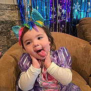 Lilya joined the competition — help win amazing prizes! celebration, chair, child, costume, cute, decorations, face, festive, happy, indoor, party, playful, princess_dress, purple_dress, rainbow_headband, sitting, snowflakes, toddler, tongue_out, unicorn_ears