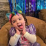 celebration, chair, child, costume, cute, decorations, face, festive, happy, indoor, party, playful, princess_dress, purple_dress, rainbow_headband, sitting, snowflakes, toddler, tongue_out, unicorn_ears