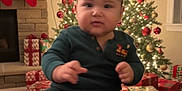Ethan joined the competition — help win amazing prizes! baby, child, christmas_tree, gift, pajamas, holiday, festive, decorations, stockings, fireplace, wrapped_presents, indoors, smiling, feet, face, sitting, holiday_lights, red, green, cozy