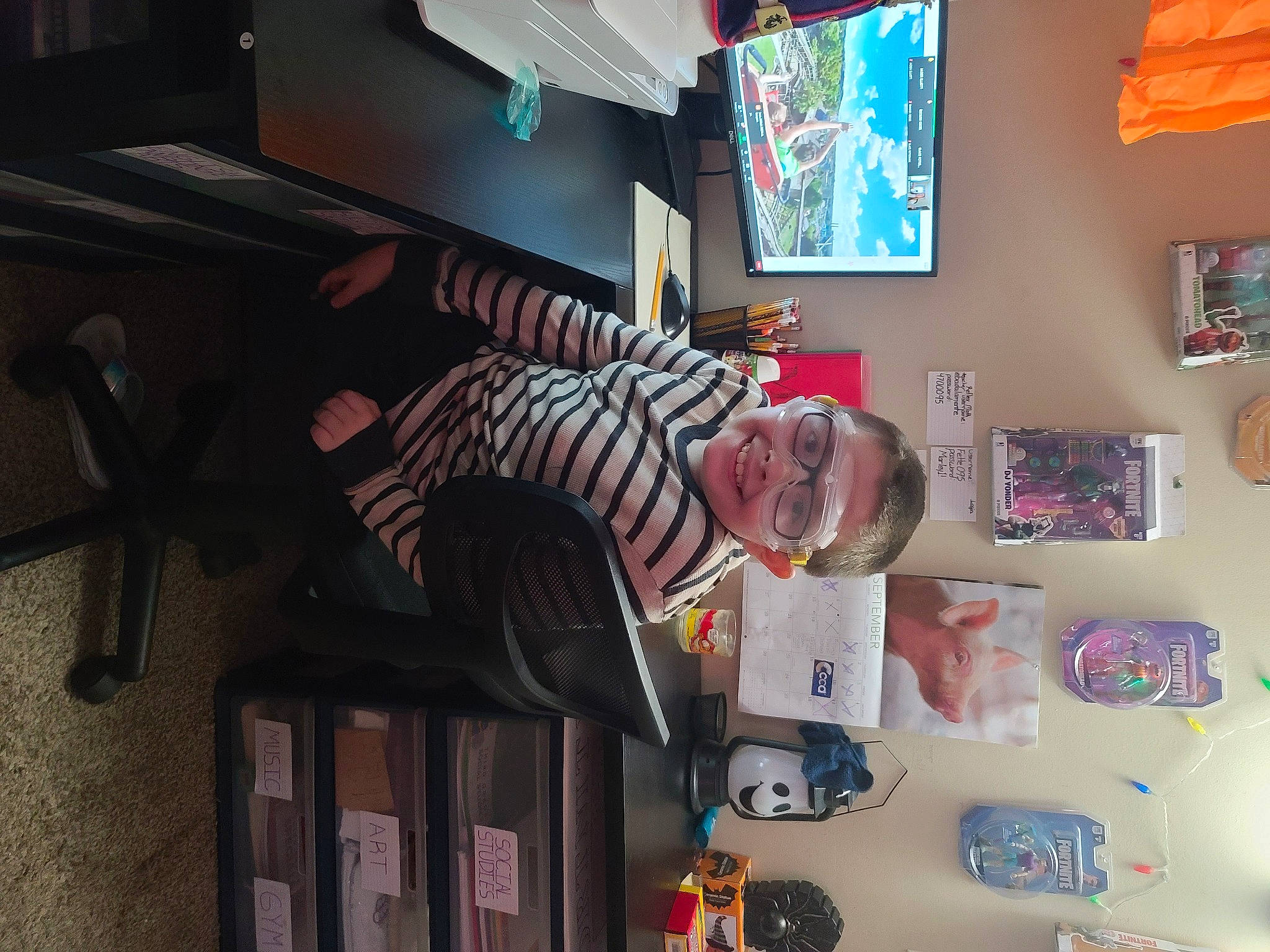 Blaize is registered to the contest to win money with this photo: bookcase, chair, child, fun, games, house, joy, machine, person, picture_frame, play, recreation, room, shelf, shelving, smile, standing, t_shirt, television, television_set