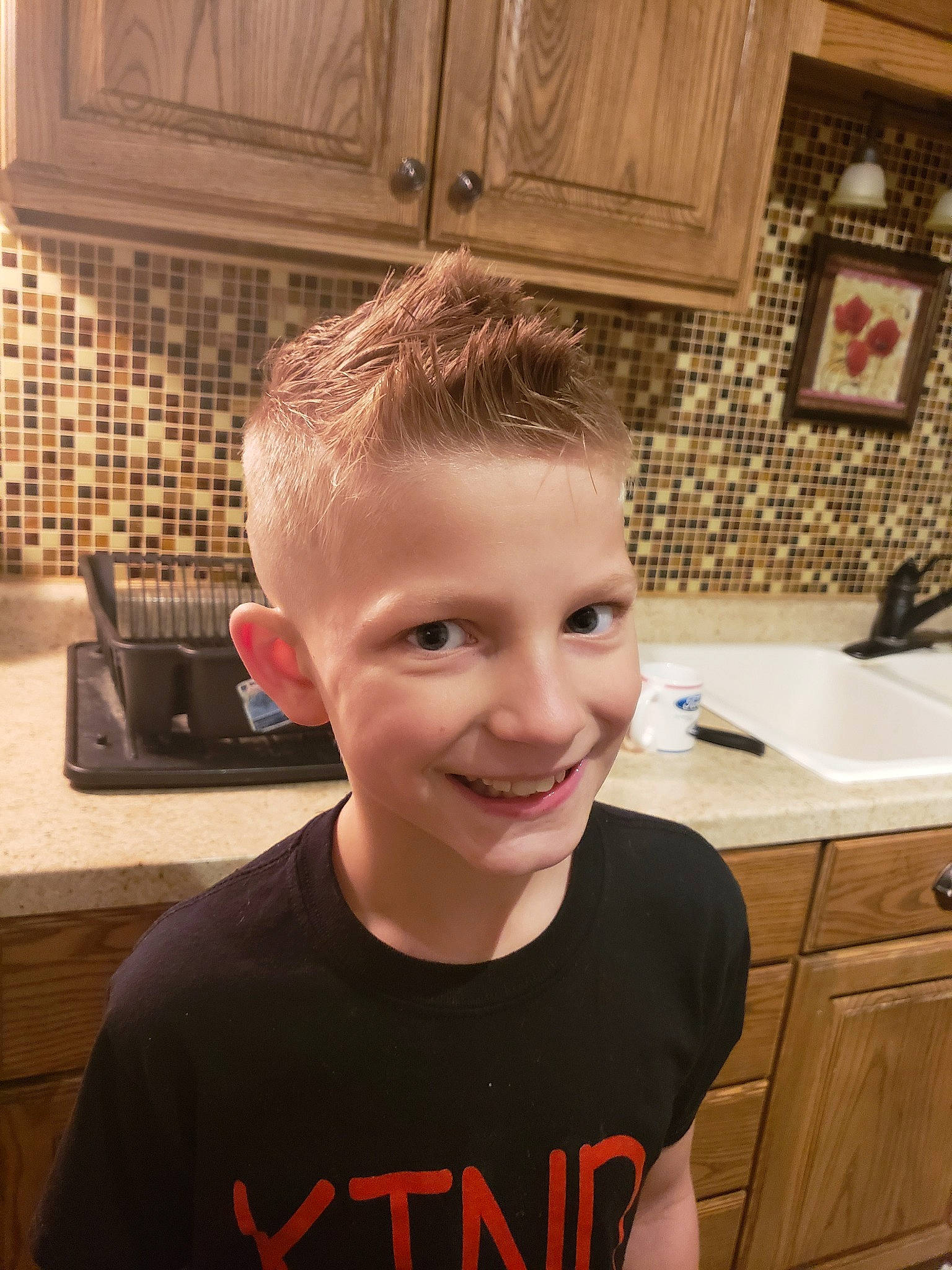 Johnathan is registered to the contest to win money with this photo: blond, brown_hair, child, chin, ear, eyebrow, face, forehead, hair, hair_coloring, hairstyle, head, jaw, joy, kitchen, nose, person, room, selfie, smile